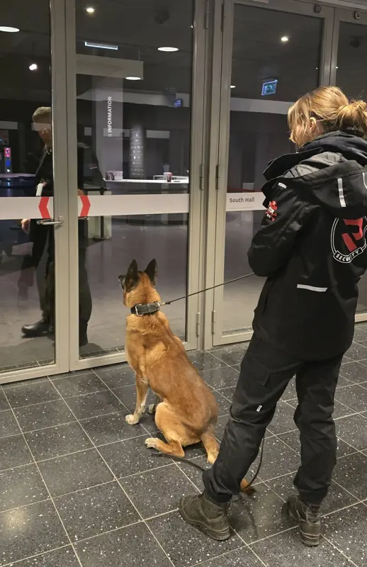 Hondengeleider van Reaction Security bij de entree van een internationale beurs